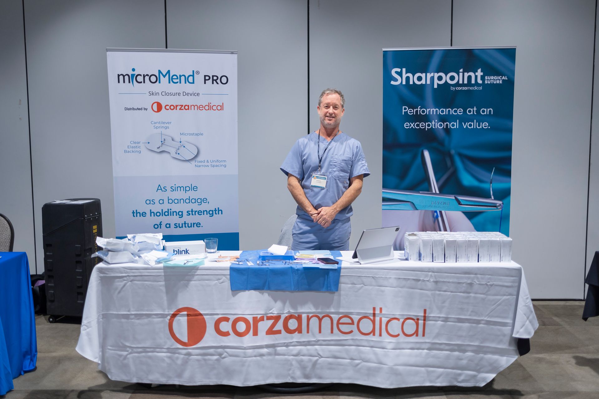 A man is standing in front of a corzamedical table