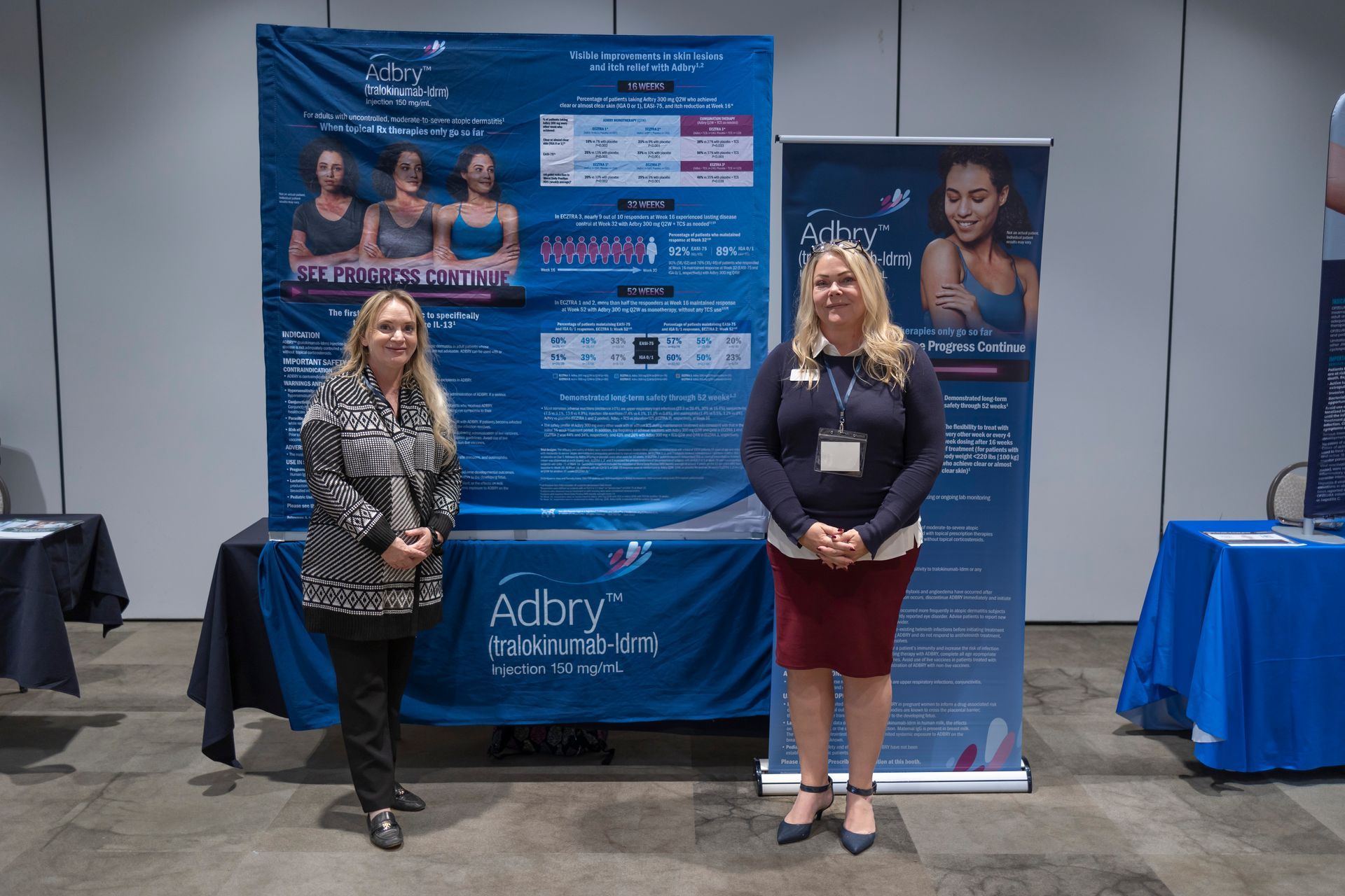 Two women standing in front of a sign that says adory