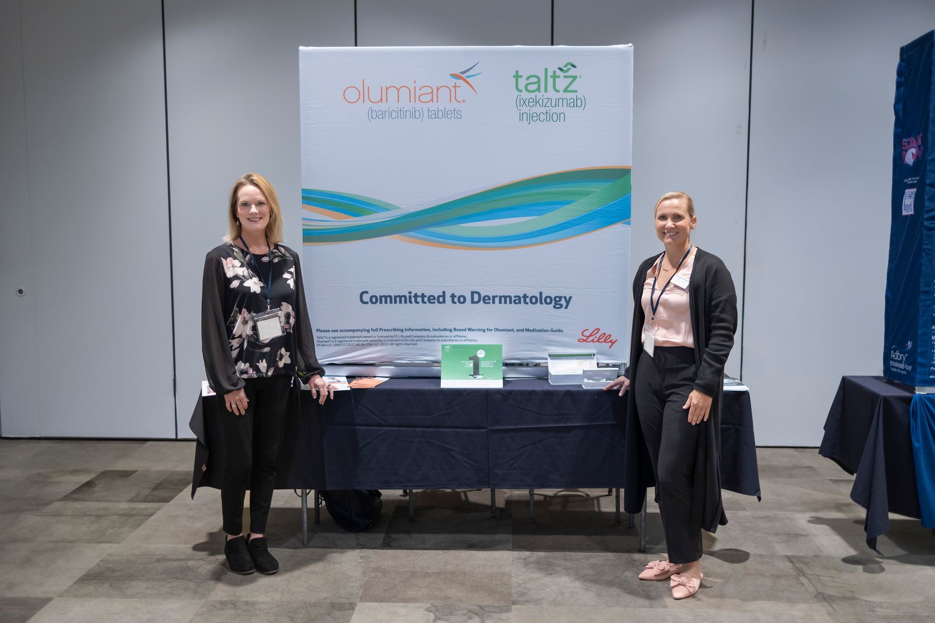 Two women are standing in front of a table in a room.