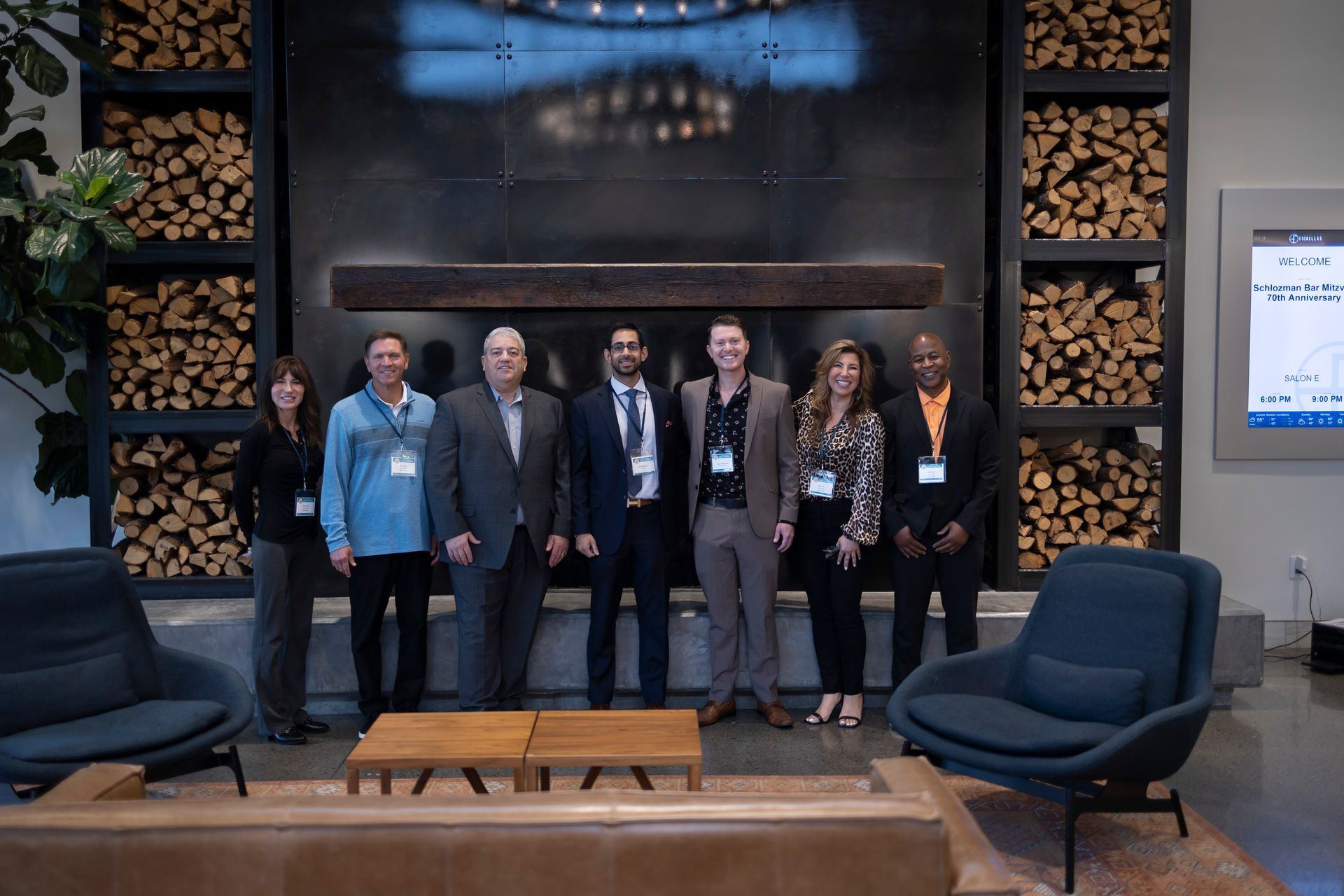 A group of people are standing in front of a fireplace in a living room.