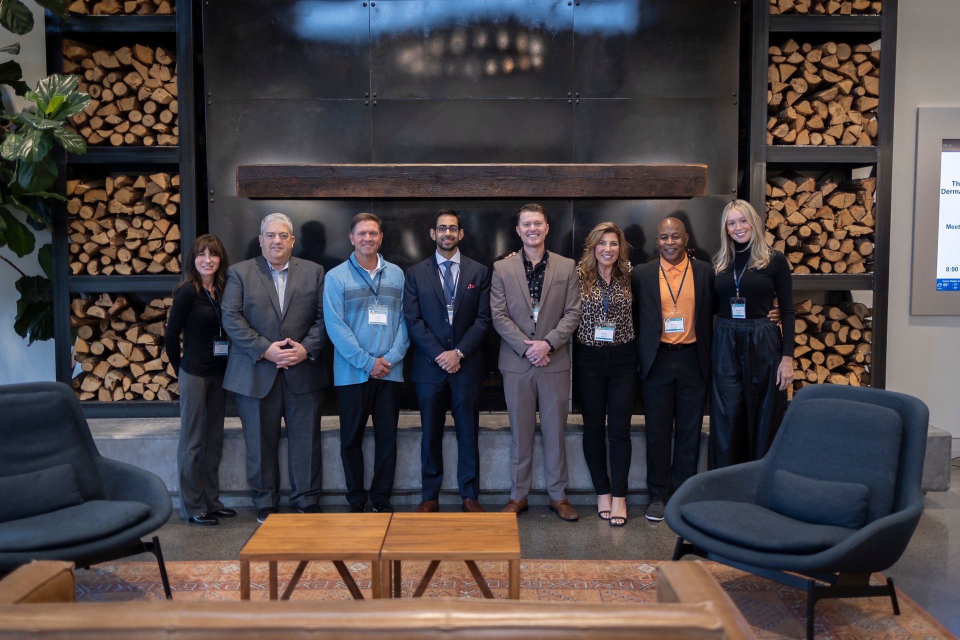 A group of people are posing for a picture in front of a fireplace.