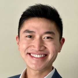 A man in a suit and tie is smiling for the camera.