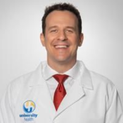 Dr. Fink in a suit and tie is smiling for the camera.