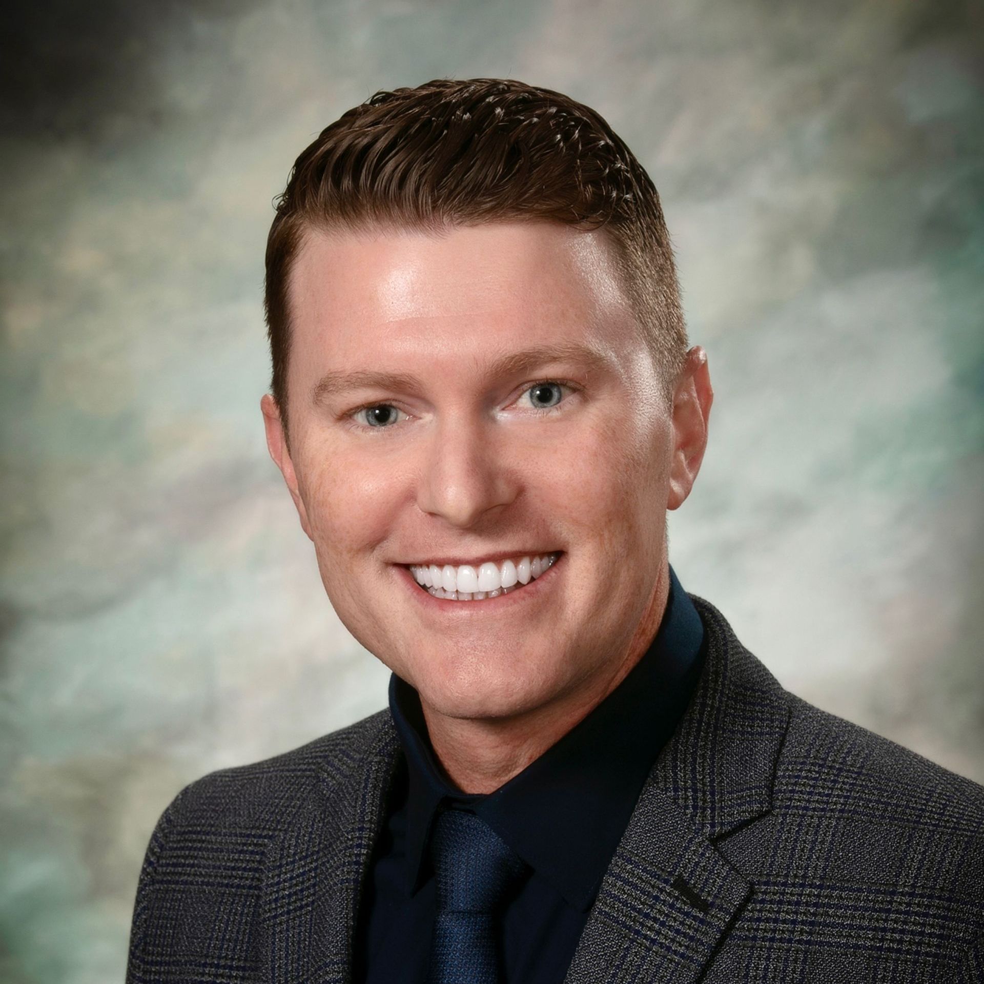 A man in a suit and tie is smiling for the camera.