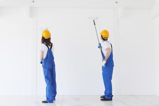 two workers painting the wall