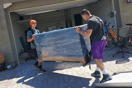 Two Men Carrying a Sofa — Peoria, AZ — New Beginnings Moving Solutions