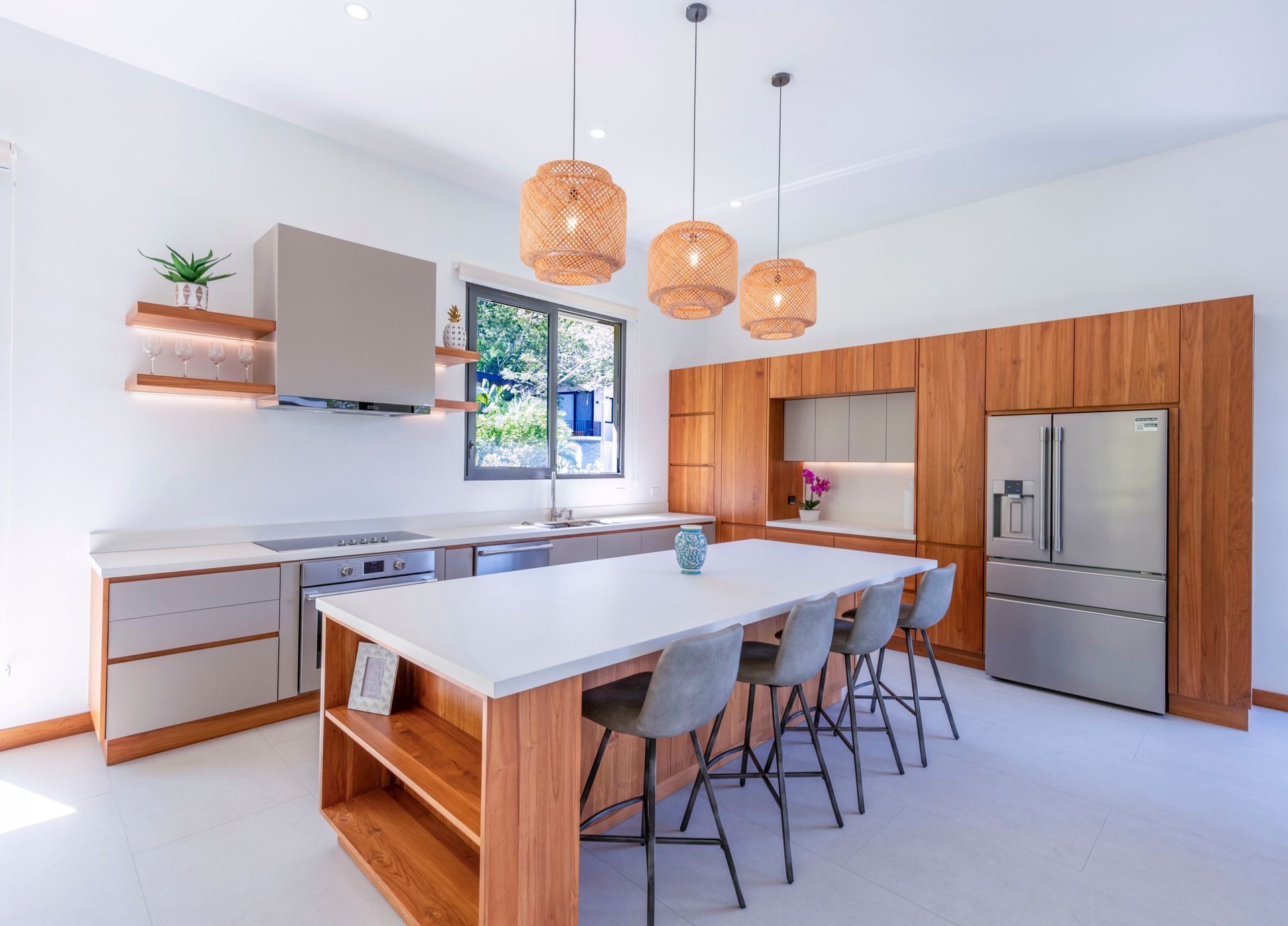 Modern kitchen with white countertops, wooden cabinets, and a large island with seating.