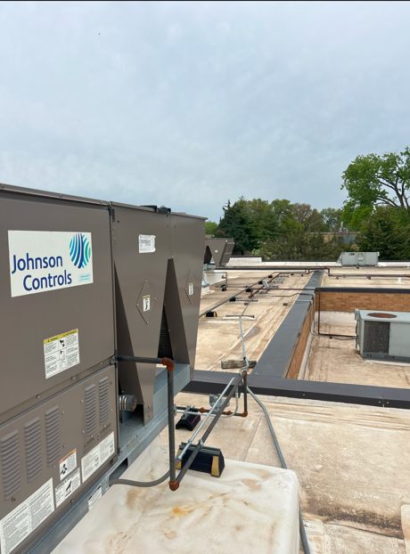 HVAC unit on a flat roof with Johnson Controls logo; overcast sky.
