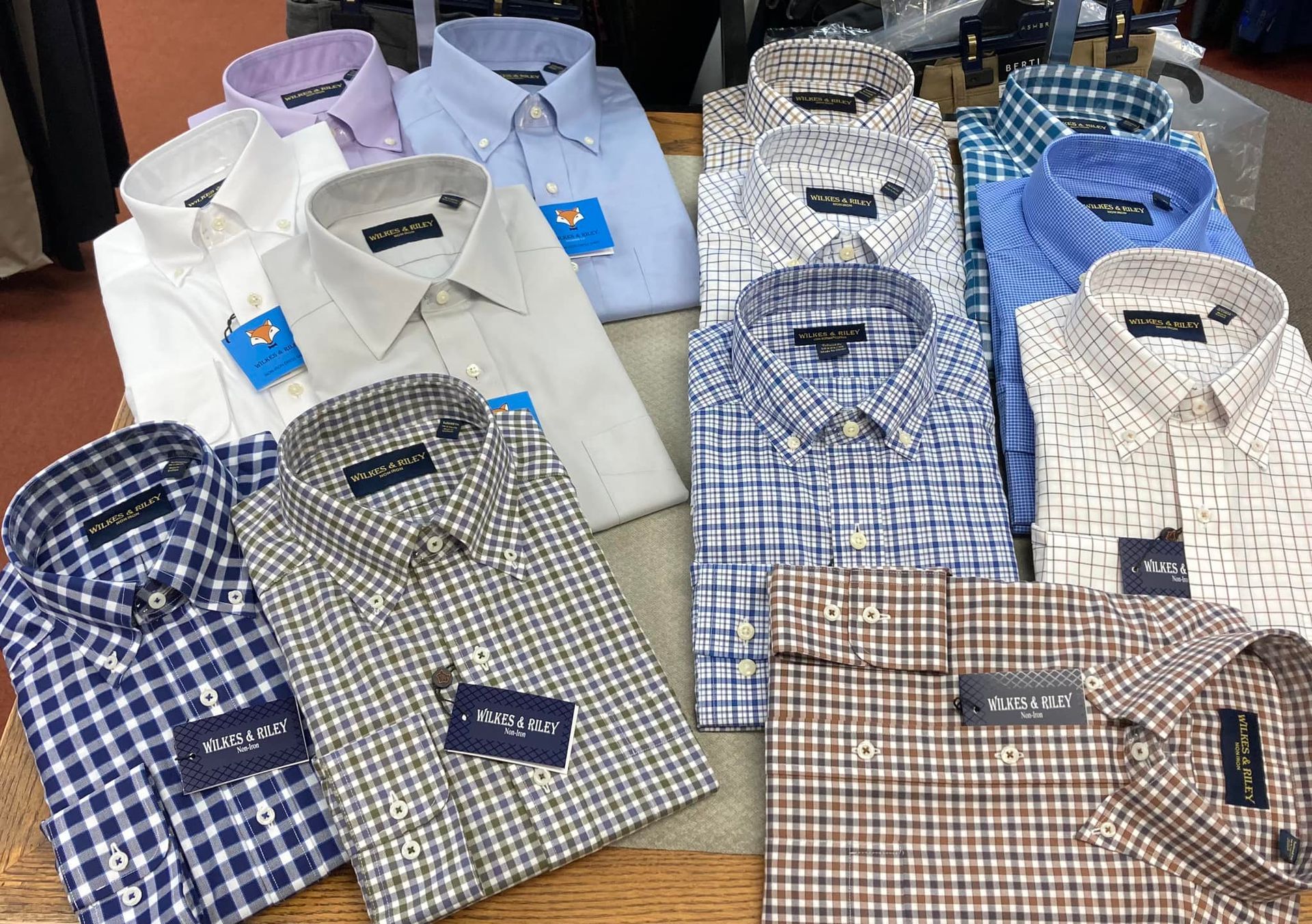 A collection of folded men's dress shirts in various colors and patterns displayed on a table.