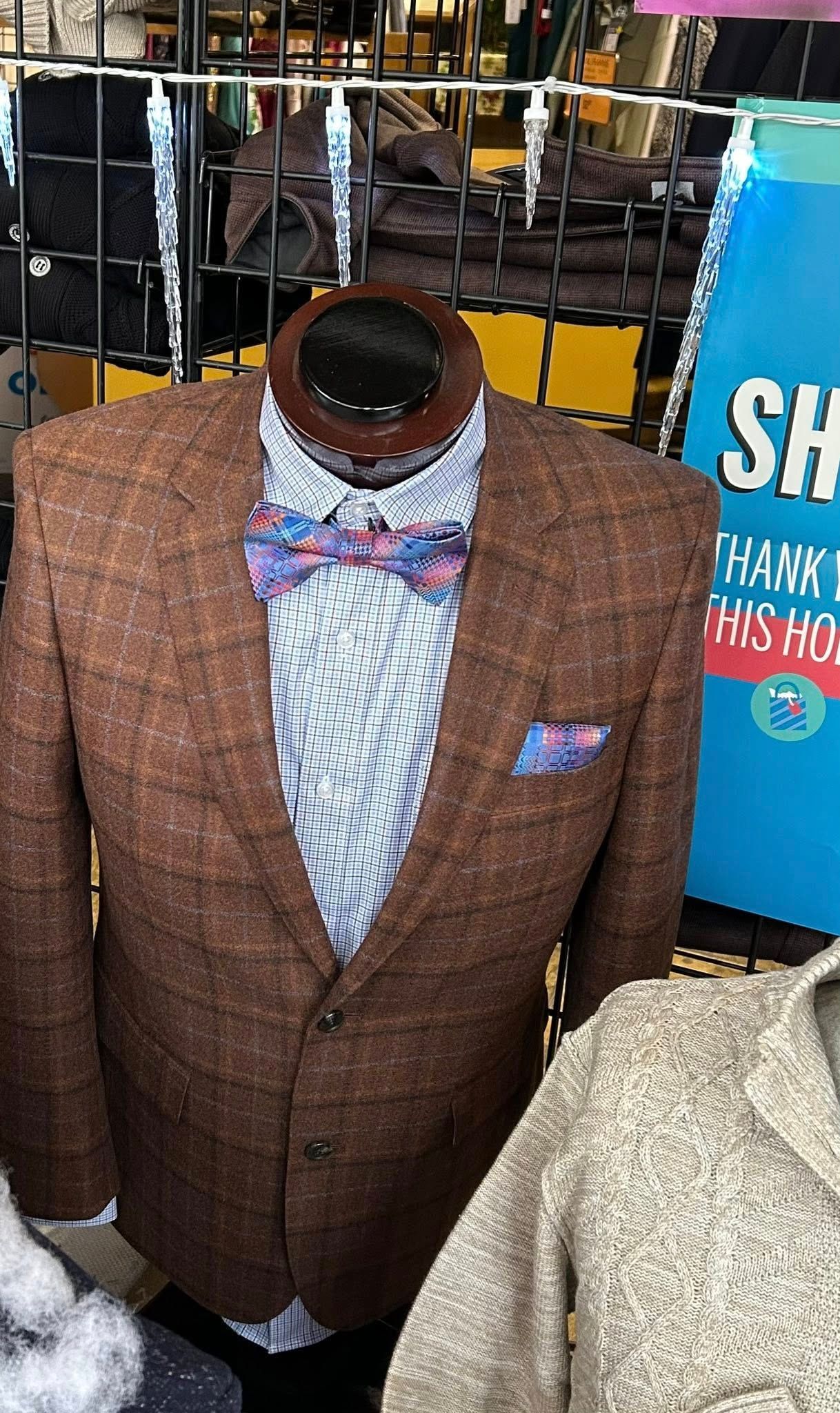 Mannequin in a brown tweed blazer, patterned bow tie, and pocket square.