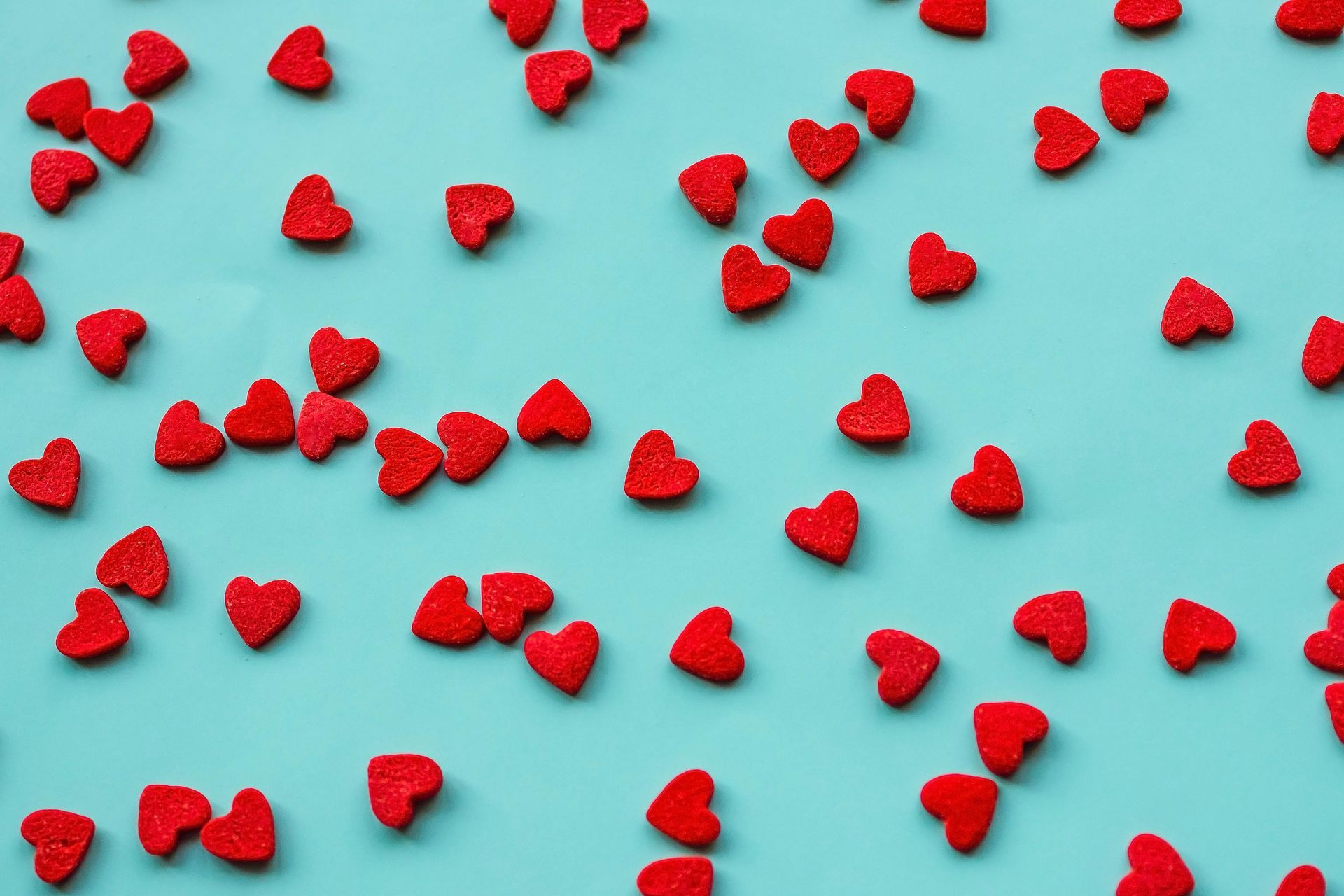 Small red hearts on blue background. Dating after loss.