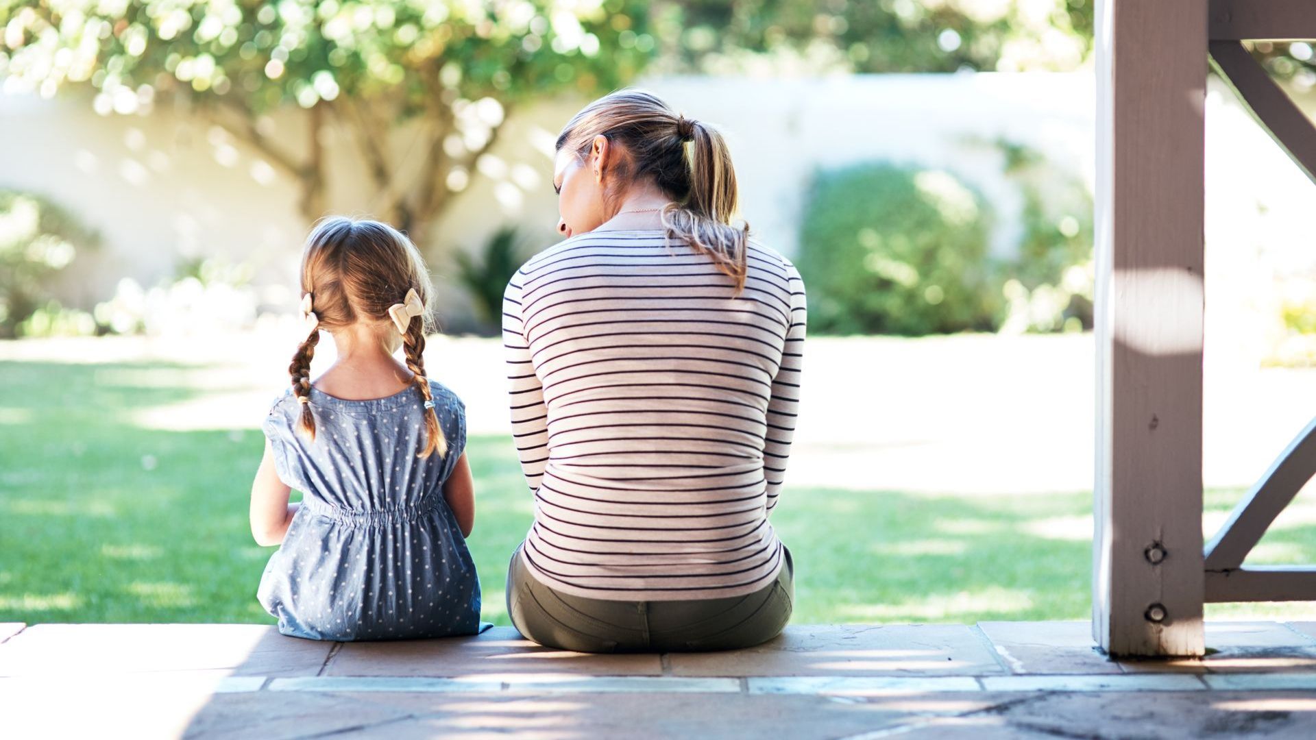 Mother and daughter discussing grief on front porch.