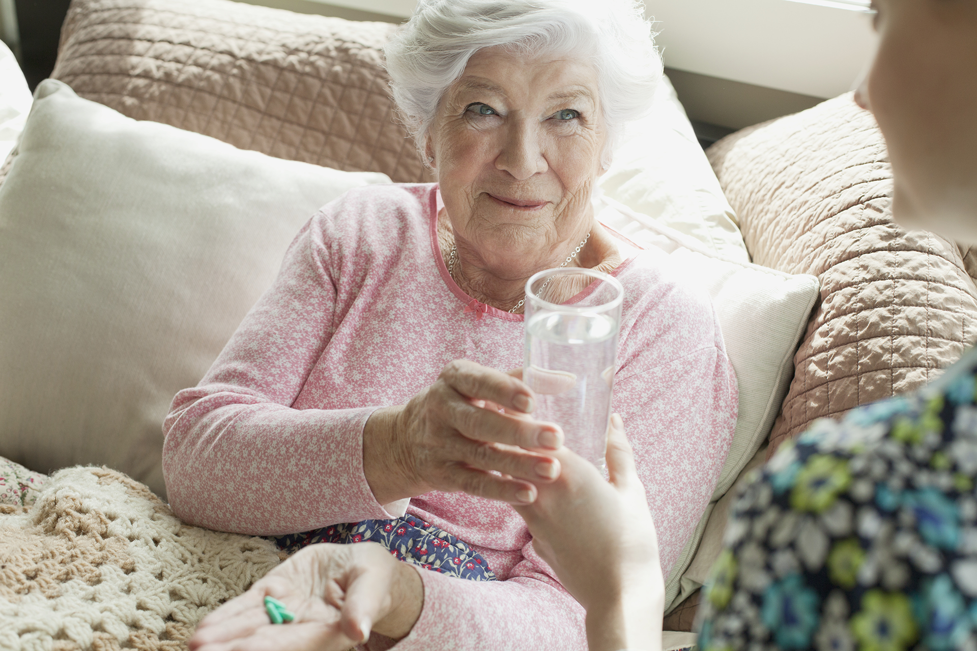 Palliative care patient receiving water from caregiver