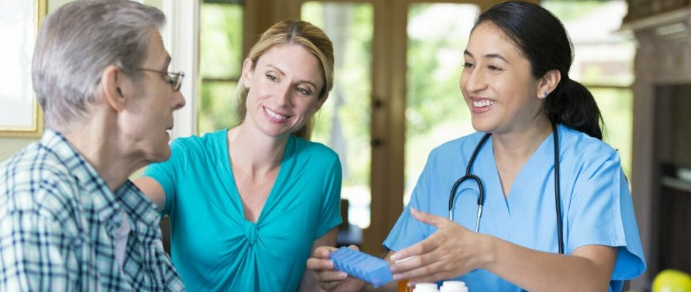 Patient sitting with caregiver and nurse