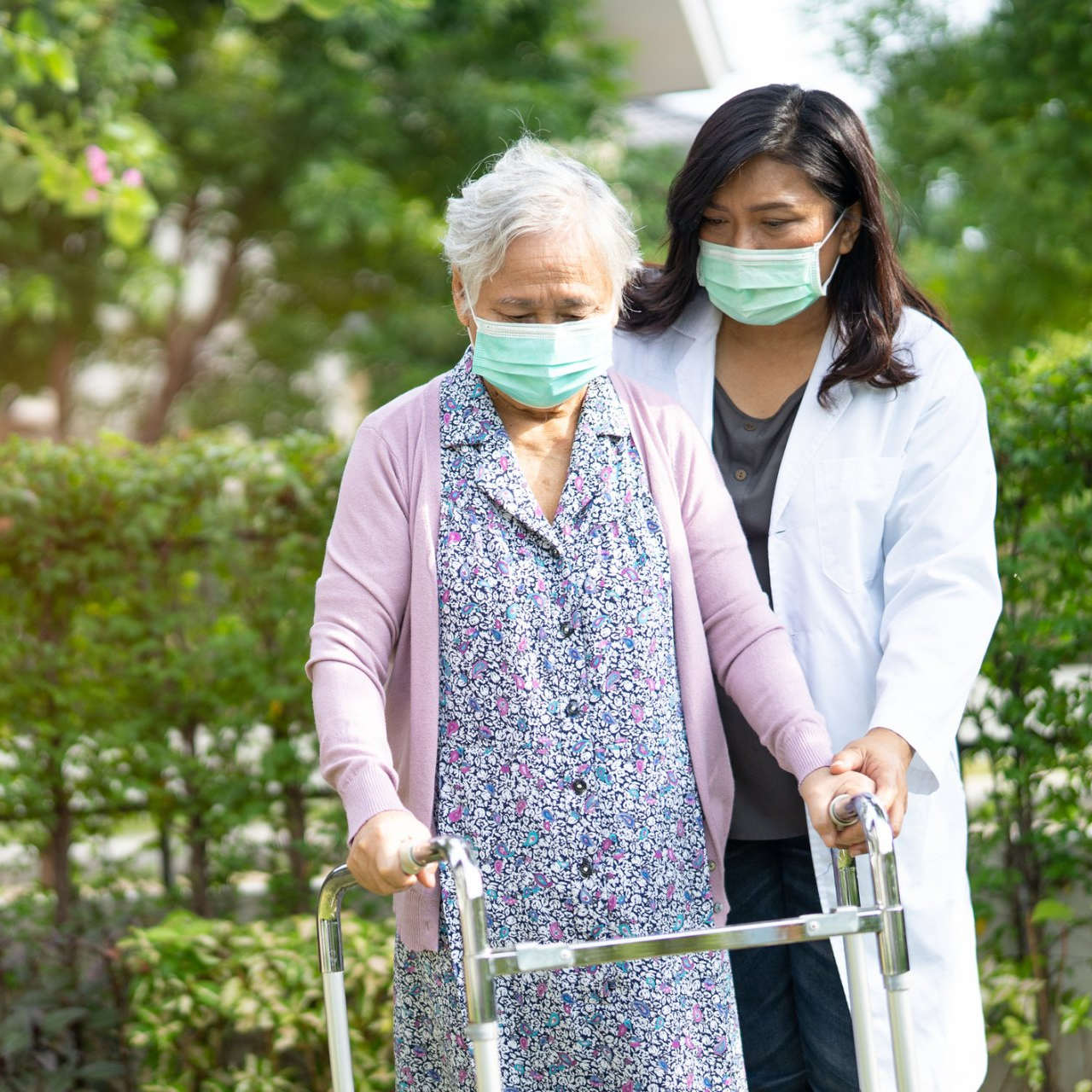 Expert Patient Care elderly woman with walker being assisted by clinical staff member