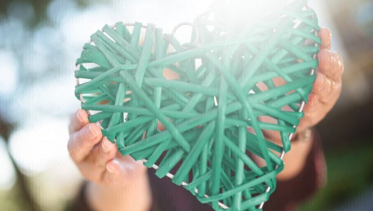 Person holding donated green heart art piece