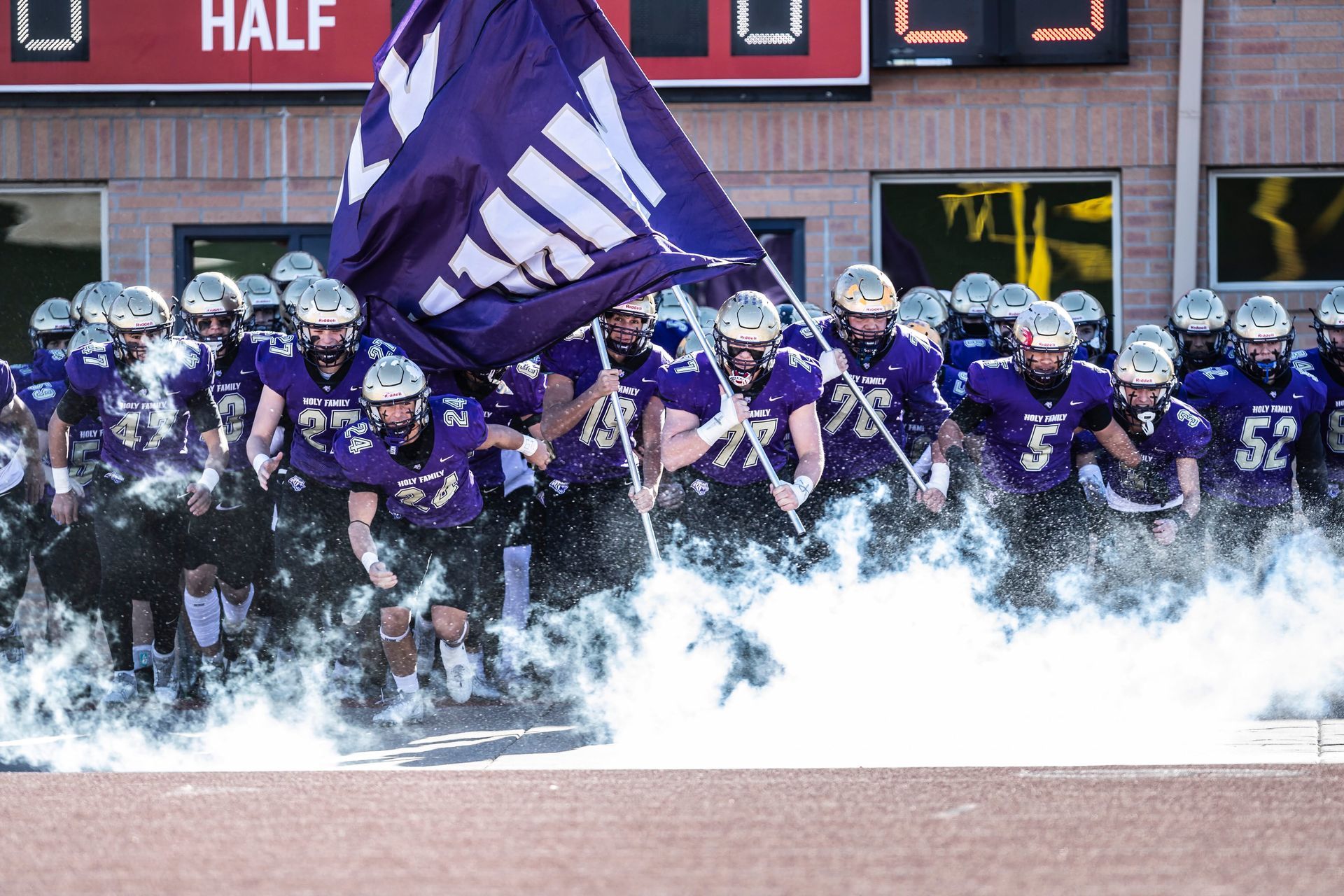 HF state championship run out with flags and smoke at CSU Pueblo.