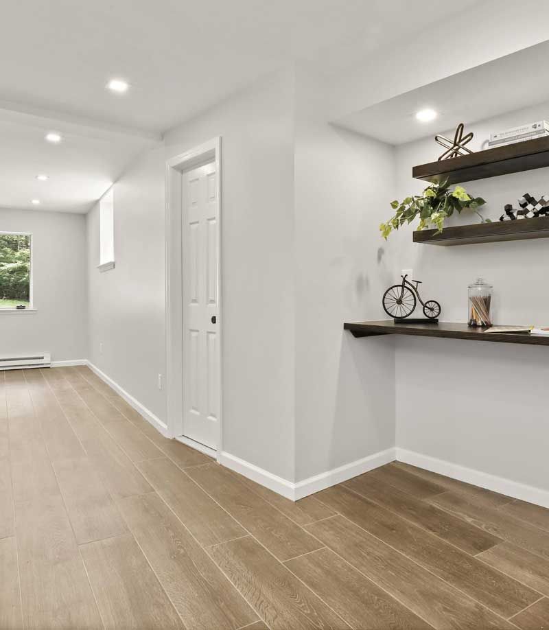 A hallway with hardwood floors and a shelf with a bicycle on it — Westchester, NY — Precision Tile, Marble & Masonry