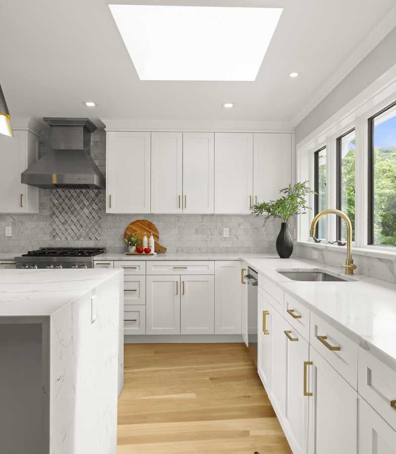 A kitchen with white cabinets , a sink , and a stove — Westchester, NY — Precision Tile, Marble & Stonework