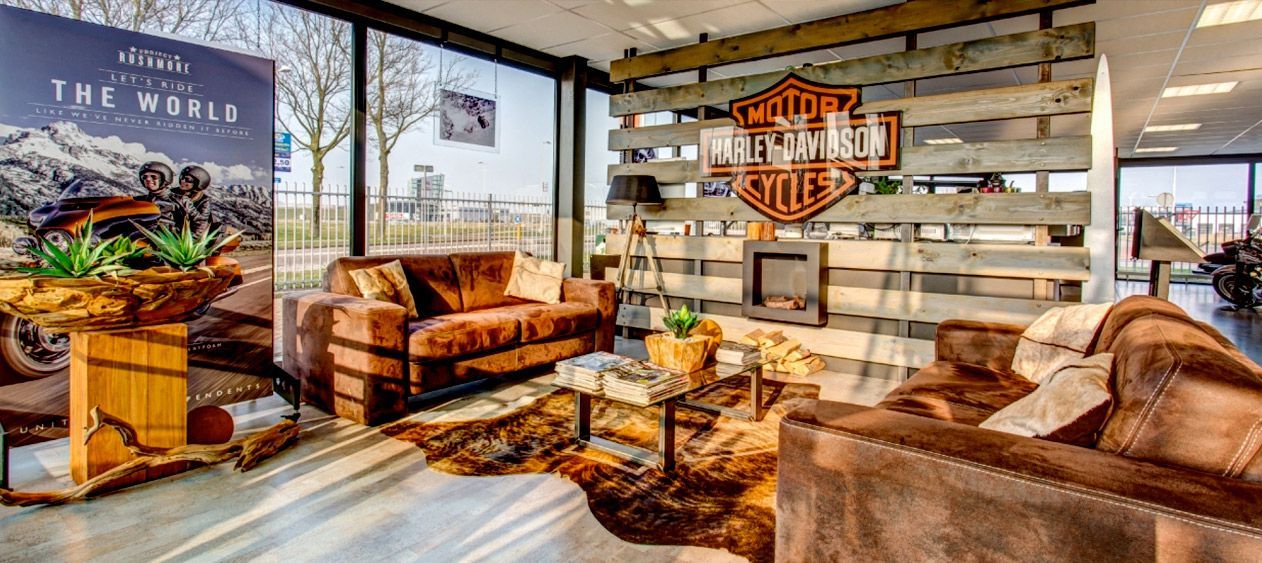 A living room filled with furniture and a harley davidson sign.