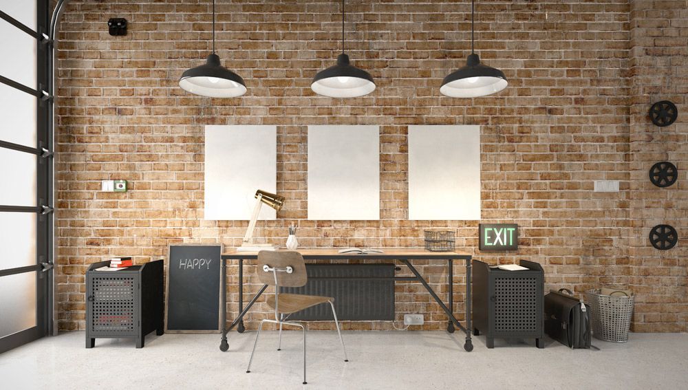 A modern office with a brick wall and a desk and chair.