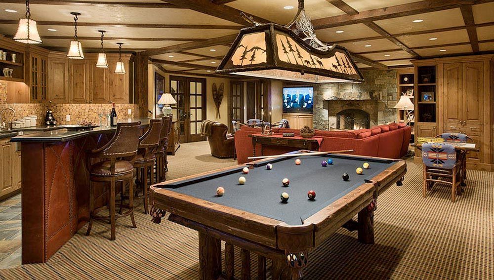 A pool table is in the middle of a living room.