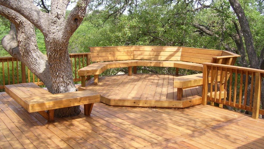 A wooden deck with a tree in the middle of it