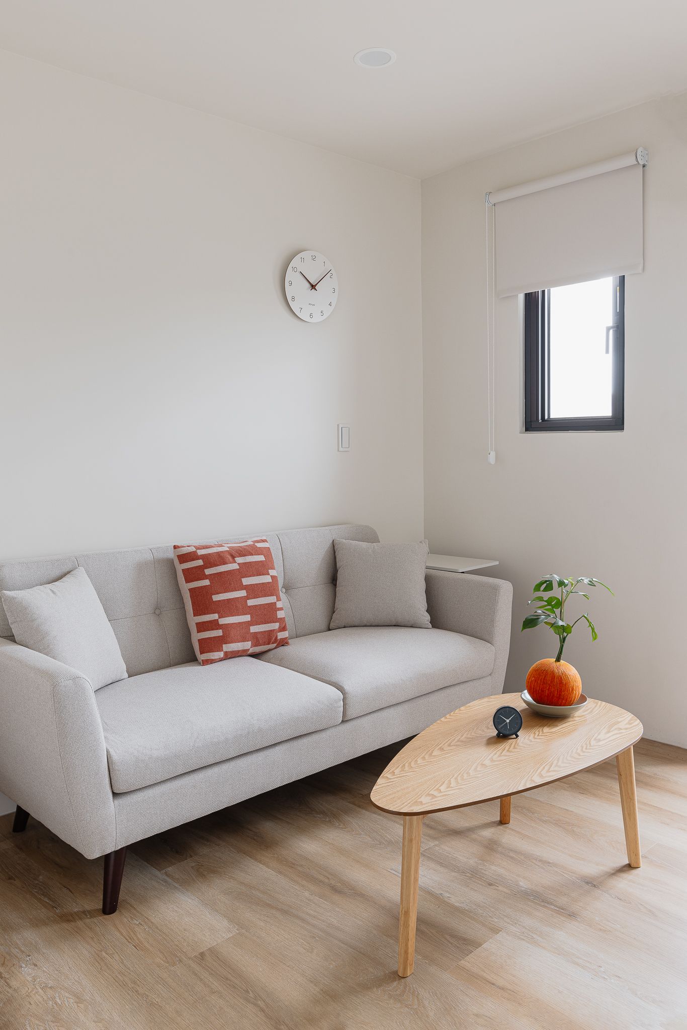 客廳配有灰色沙發、木質咖啡桌和白色牆壁。