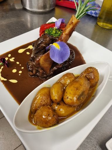 Une assiette de nourriture avec des pommes de terre et de la viande dessus