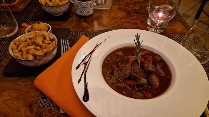 Un bol de ragoût est sur une table à côté d'un bol de frites.