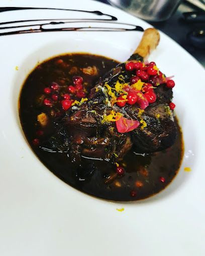 Une assiette blanche garnie d'un morceau de viande et de sauce.