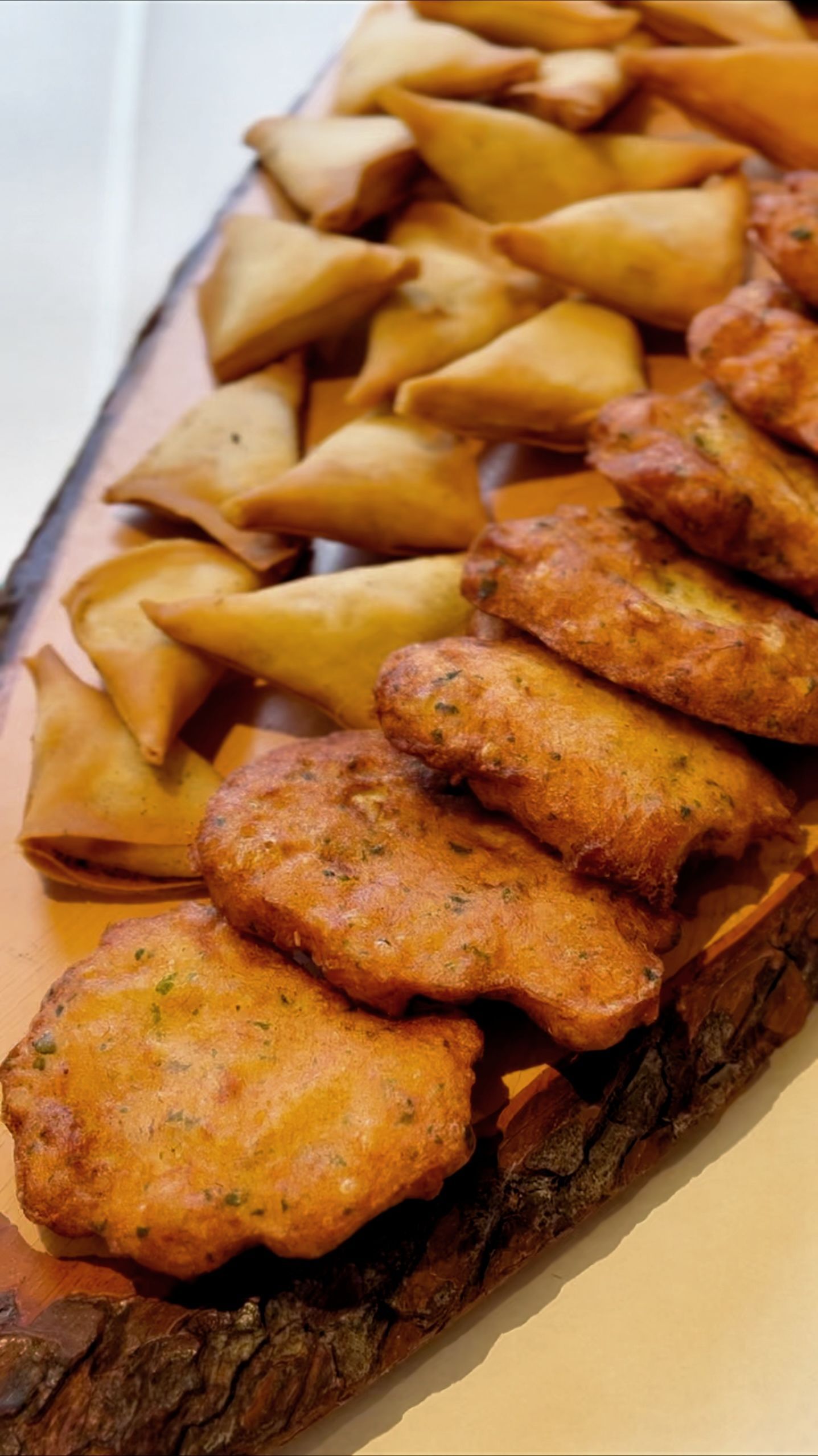 Un plateau en bois rempli d'aliments frits sur une table.