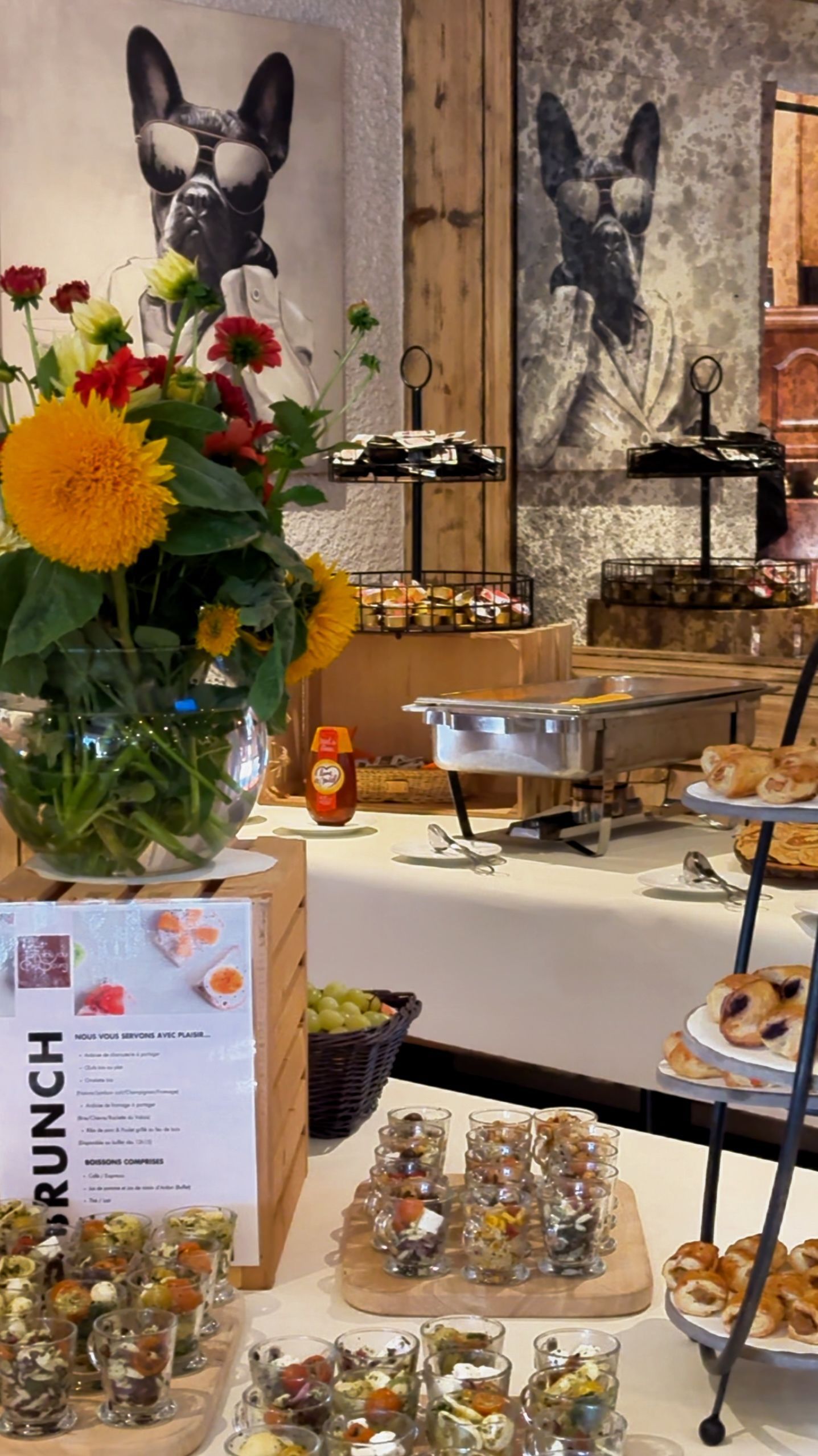 Une table de buffet avec un vase de fleurs et une photo d'un chien sur le mur.