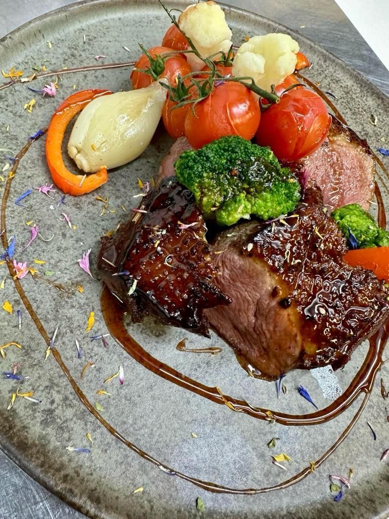 Un gros plan d'une assiette de nourriture avec de la viande et des légumes sur une table.