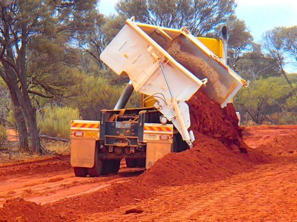A side tipper dumping dirt.