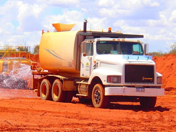 A white water truck suppressing dust.