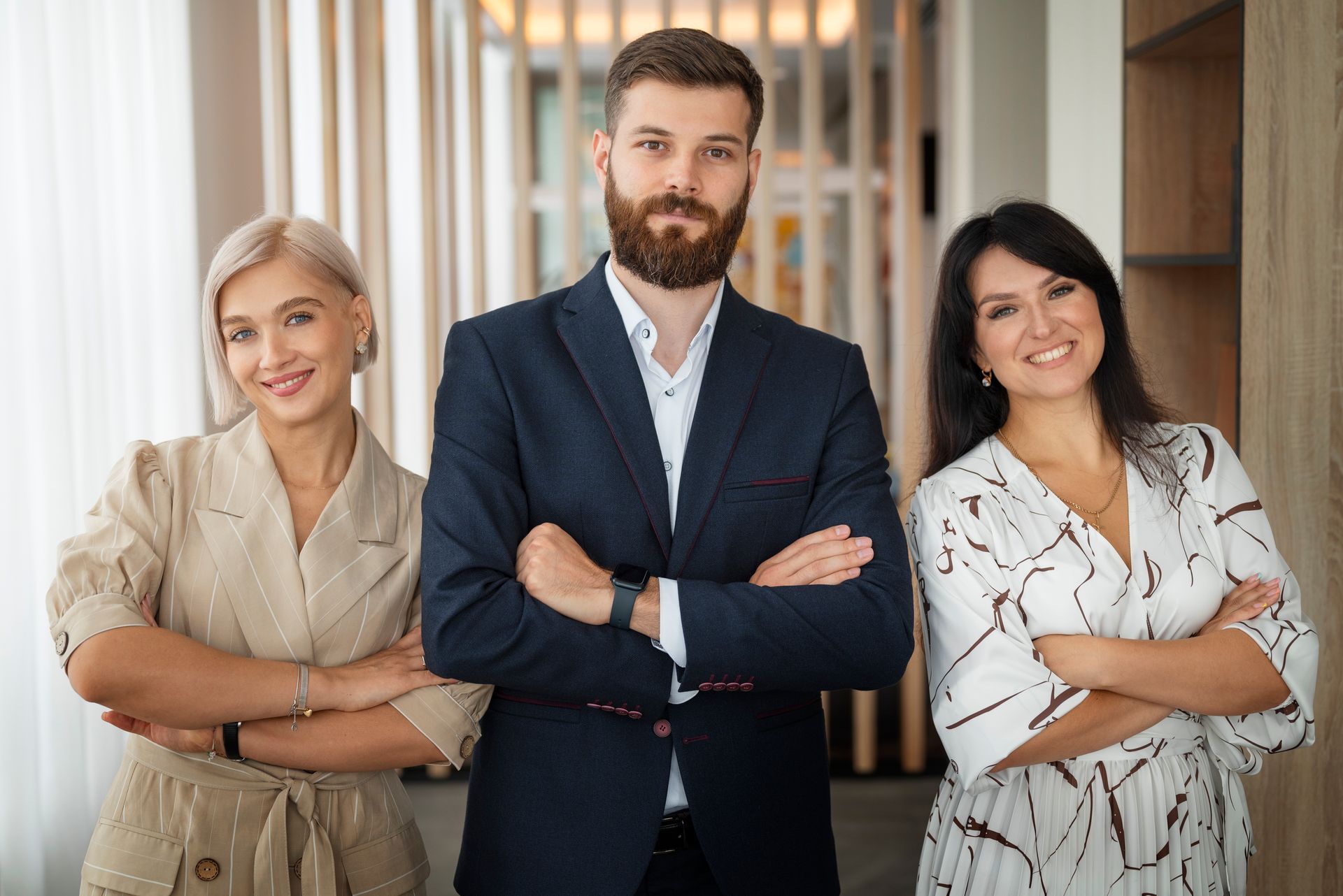 A man and two women are standing next to each other with their arms crossed.