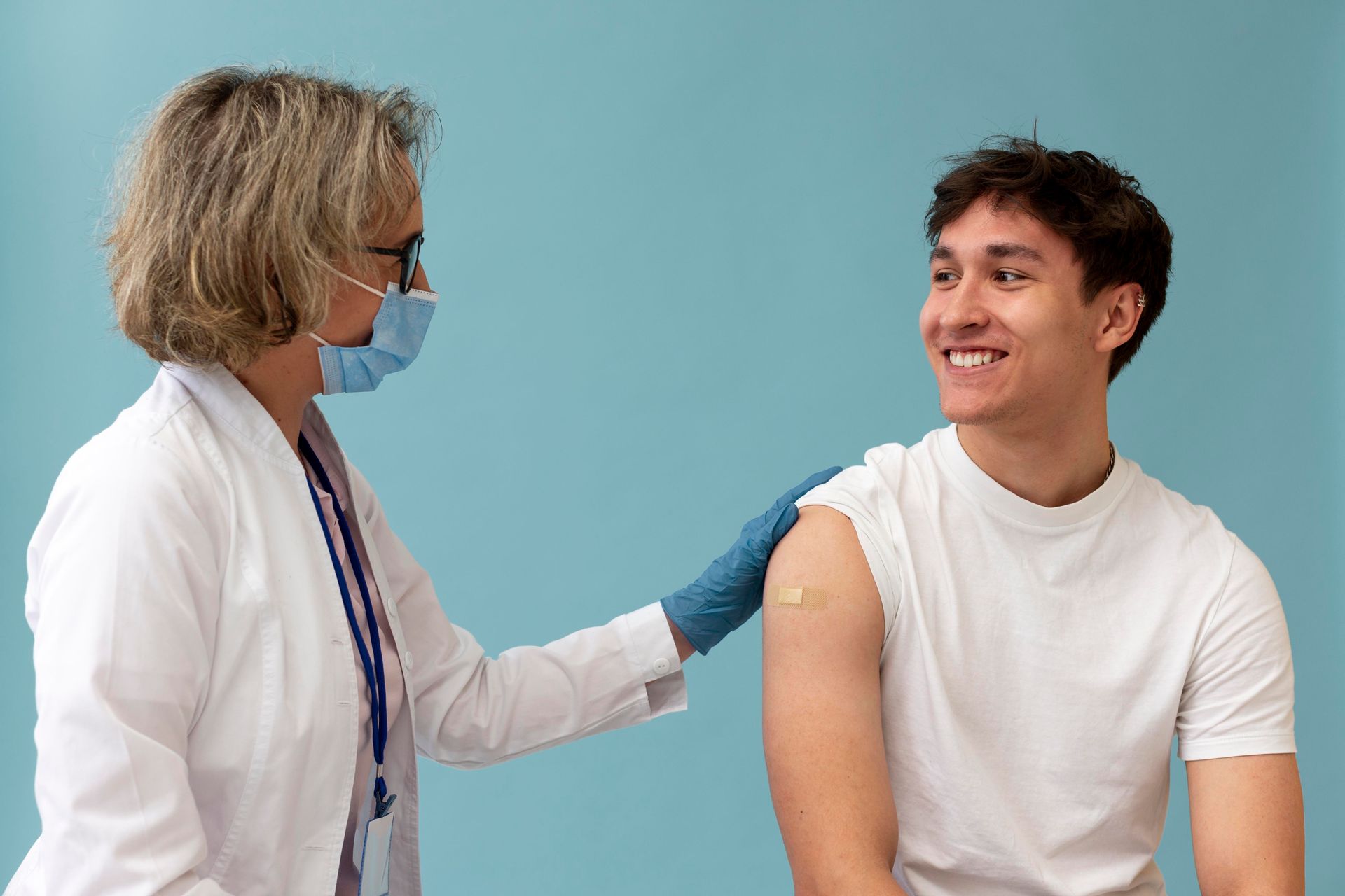 A doctor is giving a man a vaccine in his arm.
