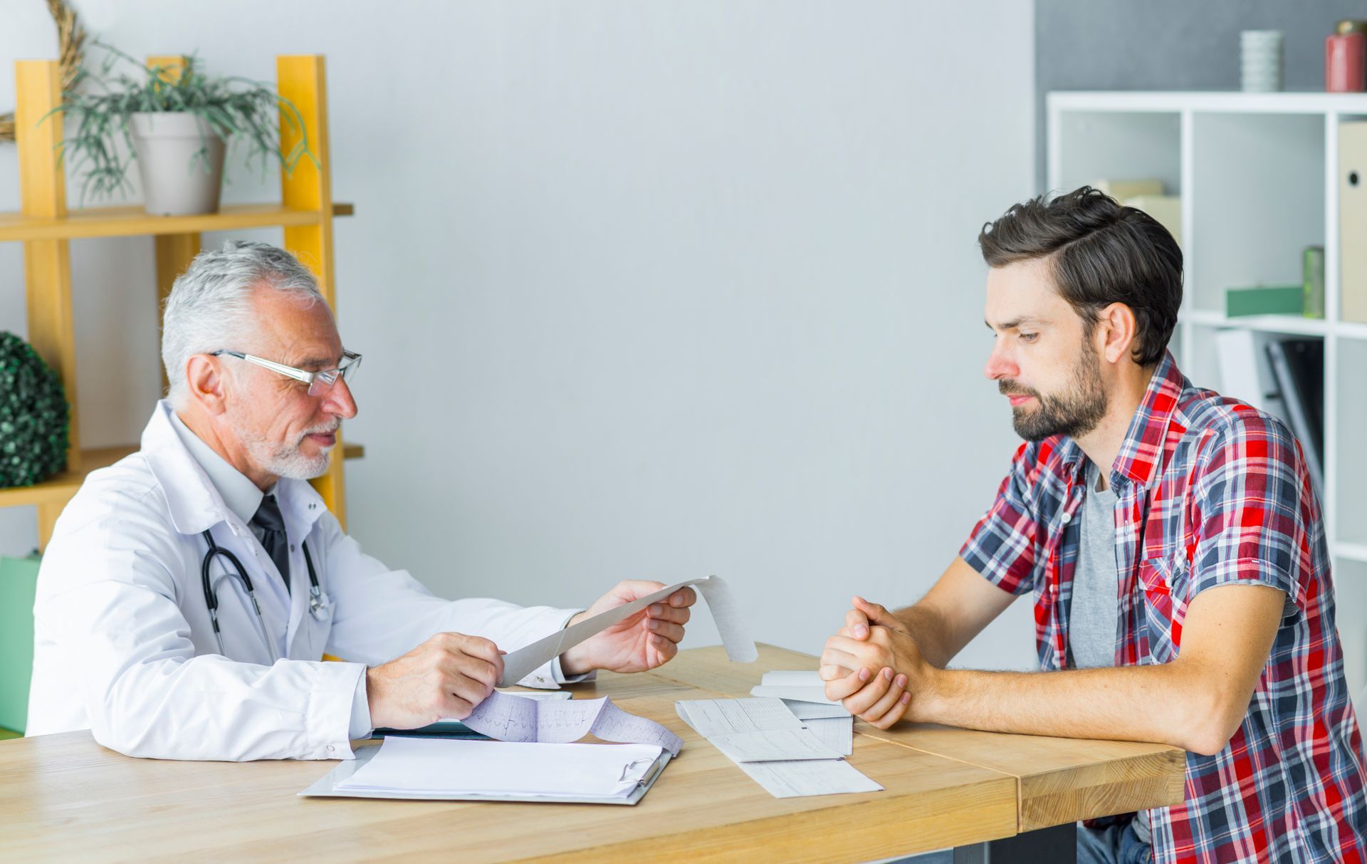 A man is sitting at a table talking to a doctor.