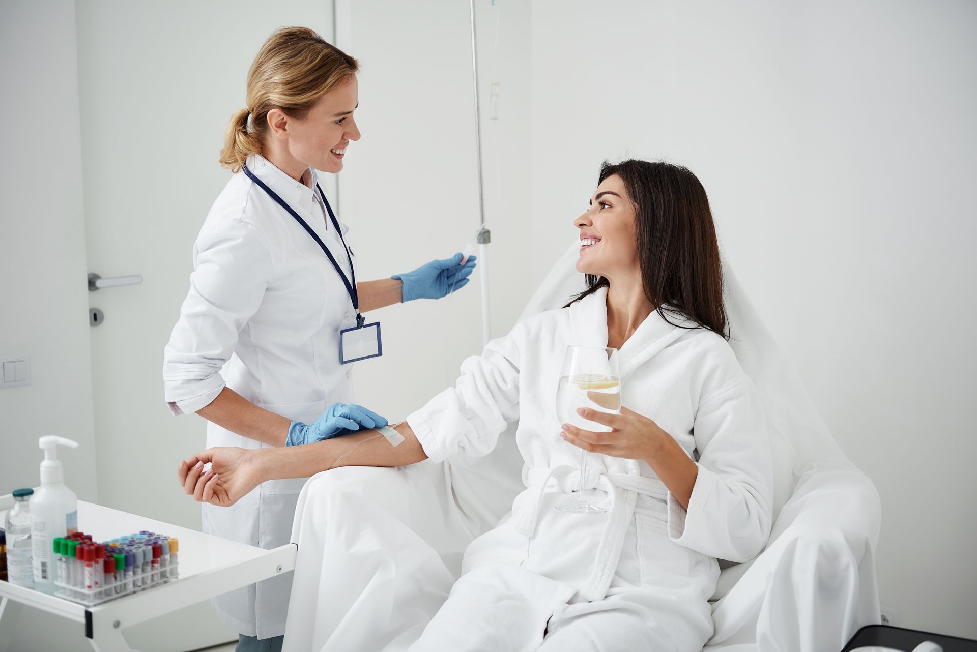 A woman is sitting in a hospital bed getting an injection from a doctor.