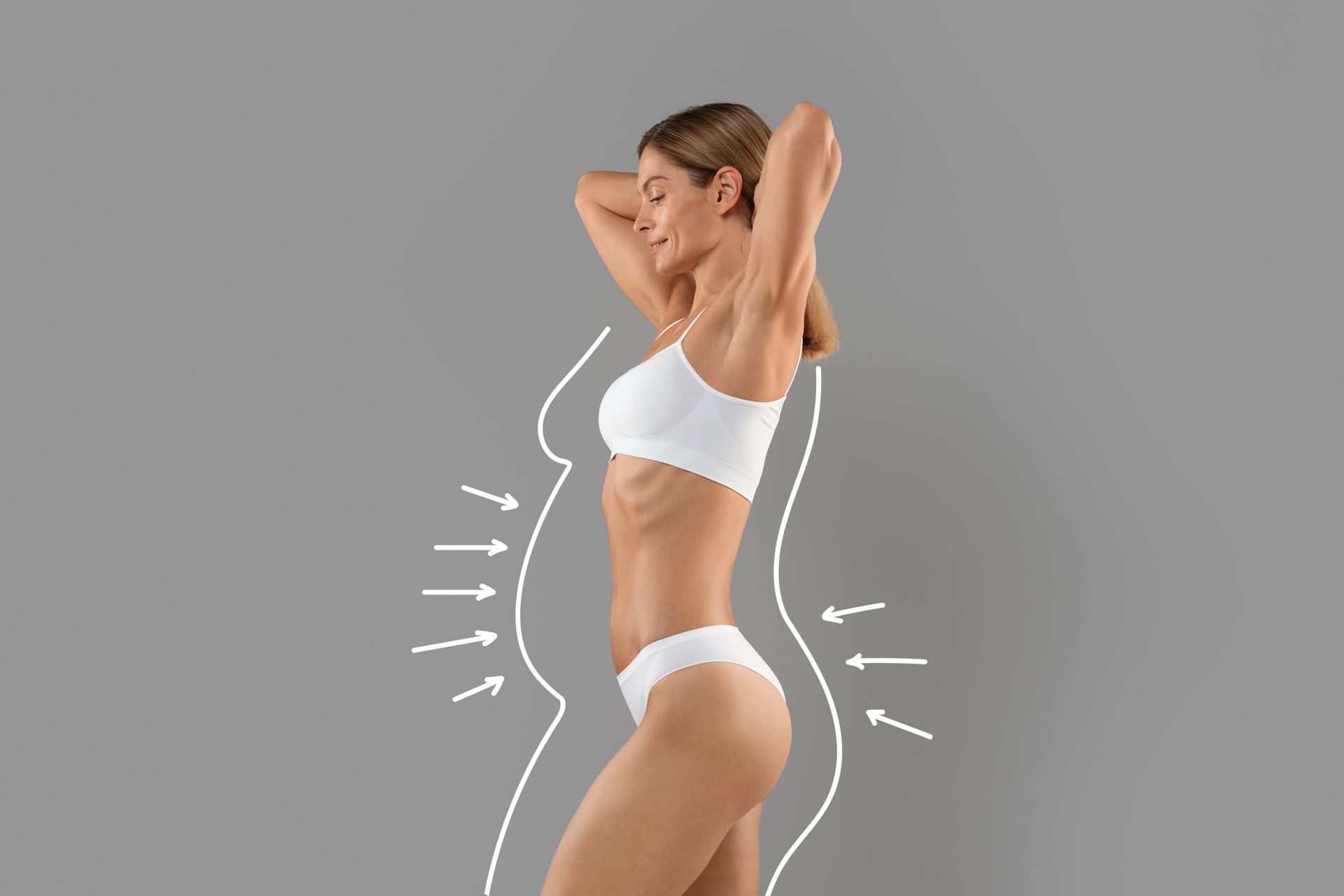 A woman in white underwear is standing on a gray background.