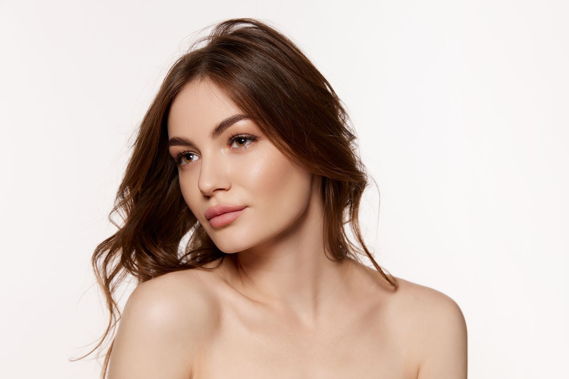 A close up of a woman 's face with long hair on a white background.