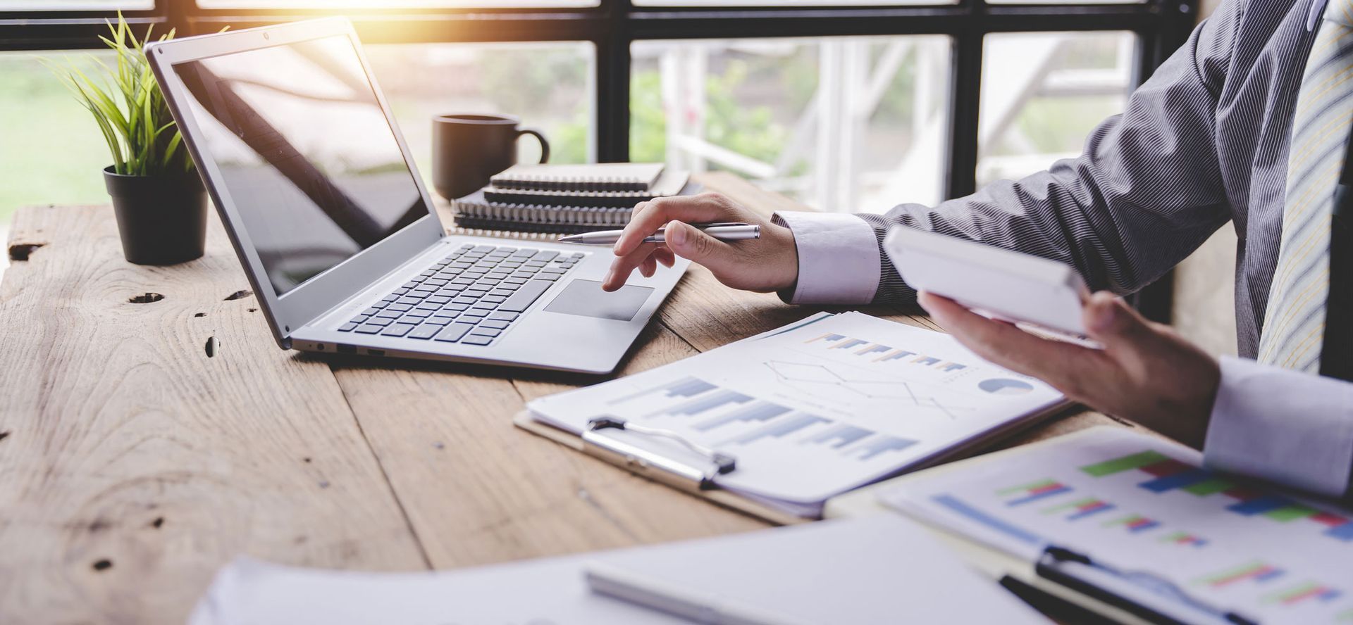 Portrait of a tax accountant working on a computer in a modern office, making an analysis report.