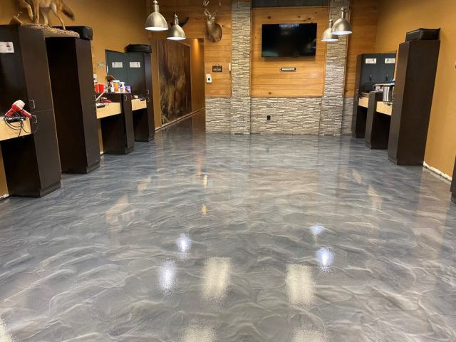 Metallic gray epoxy flooring in a barbershop with wooden accents.