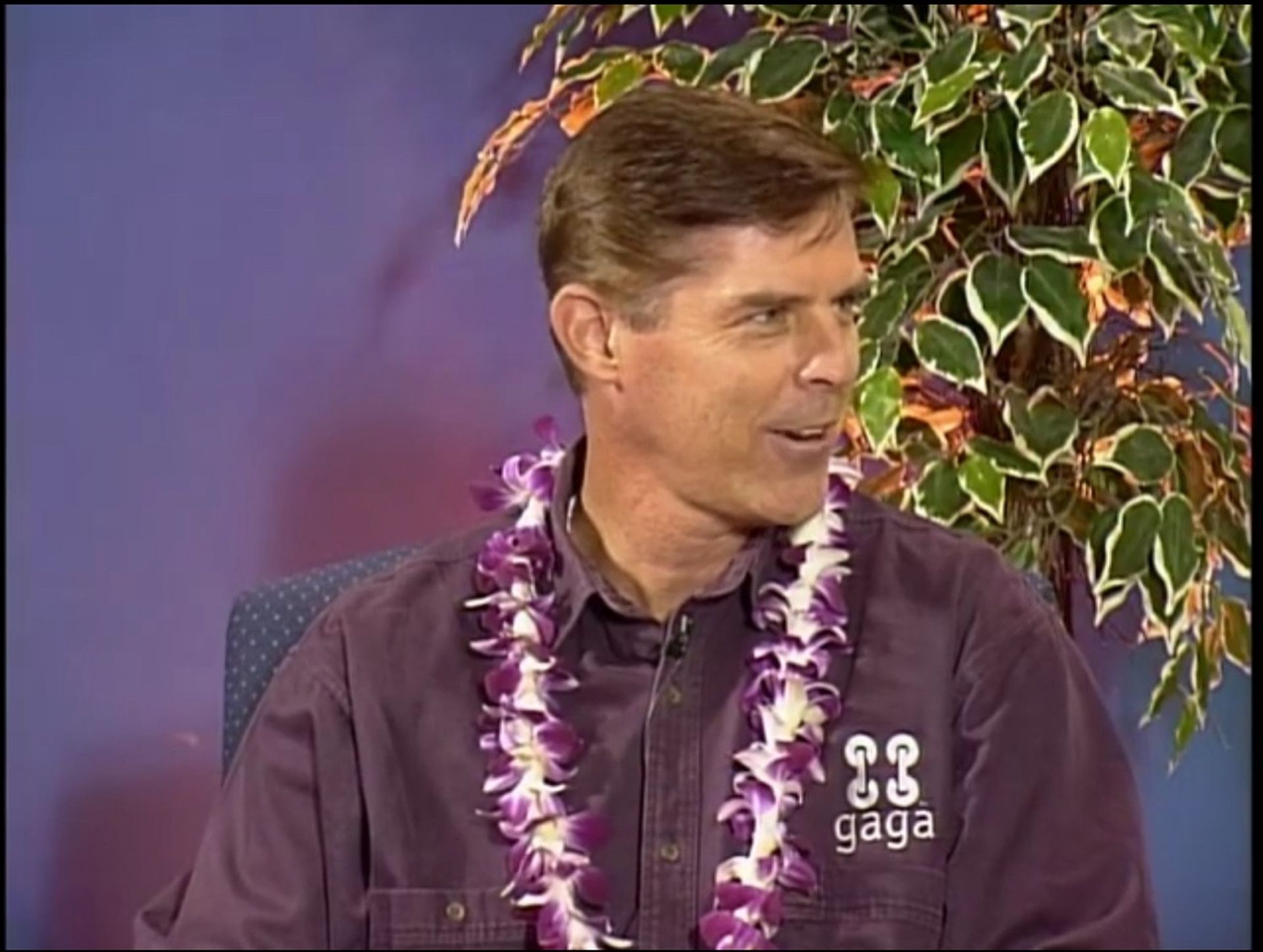 Tom Wright is wearing a purple shirt that says gaga on it