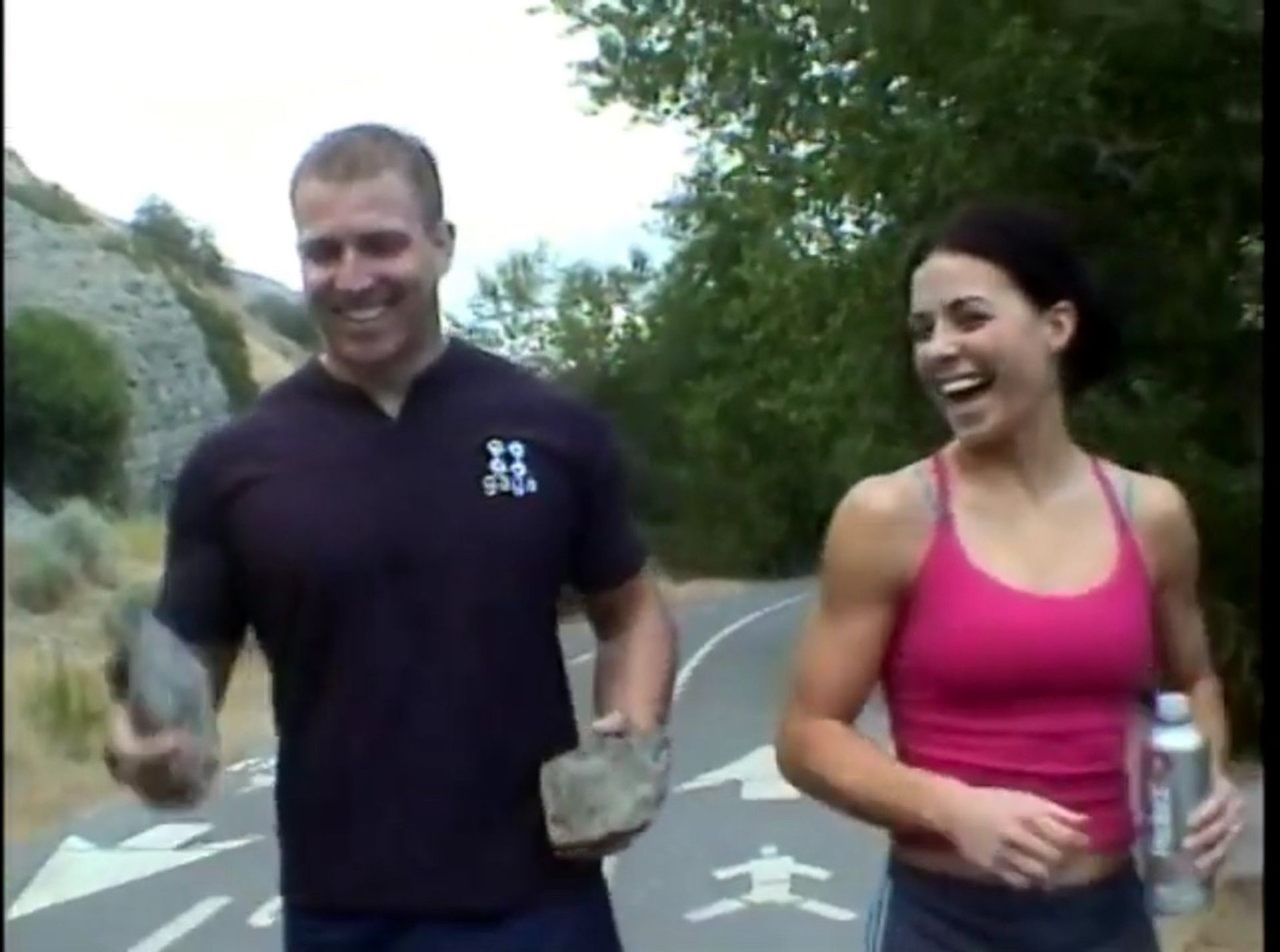 Tom Wright and a woman are walking down a road.