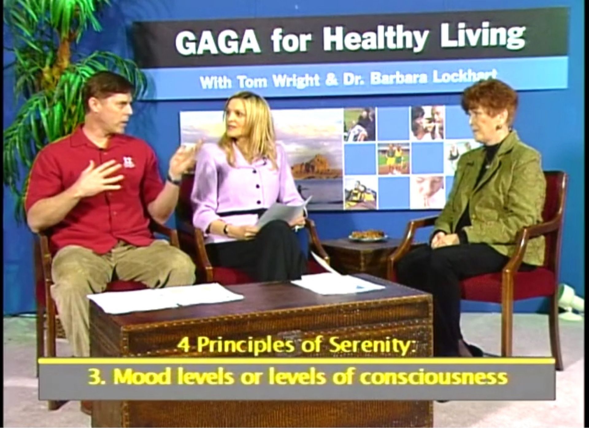 Three people are sitting at a table with gaga for healthy living written on the wall behind them