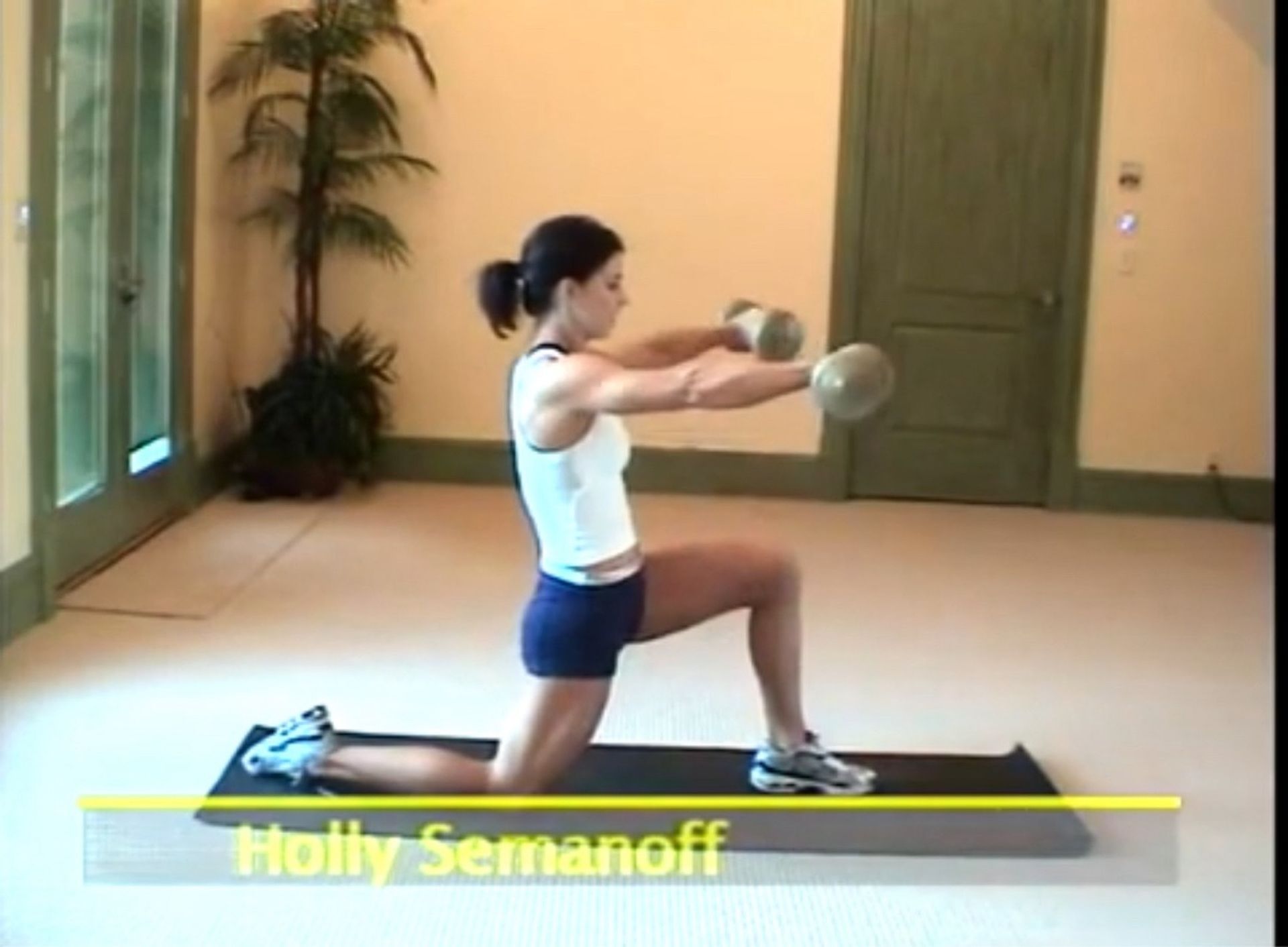 Holly semanoff is doing exercises with dumbbells on a mat