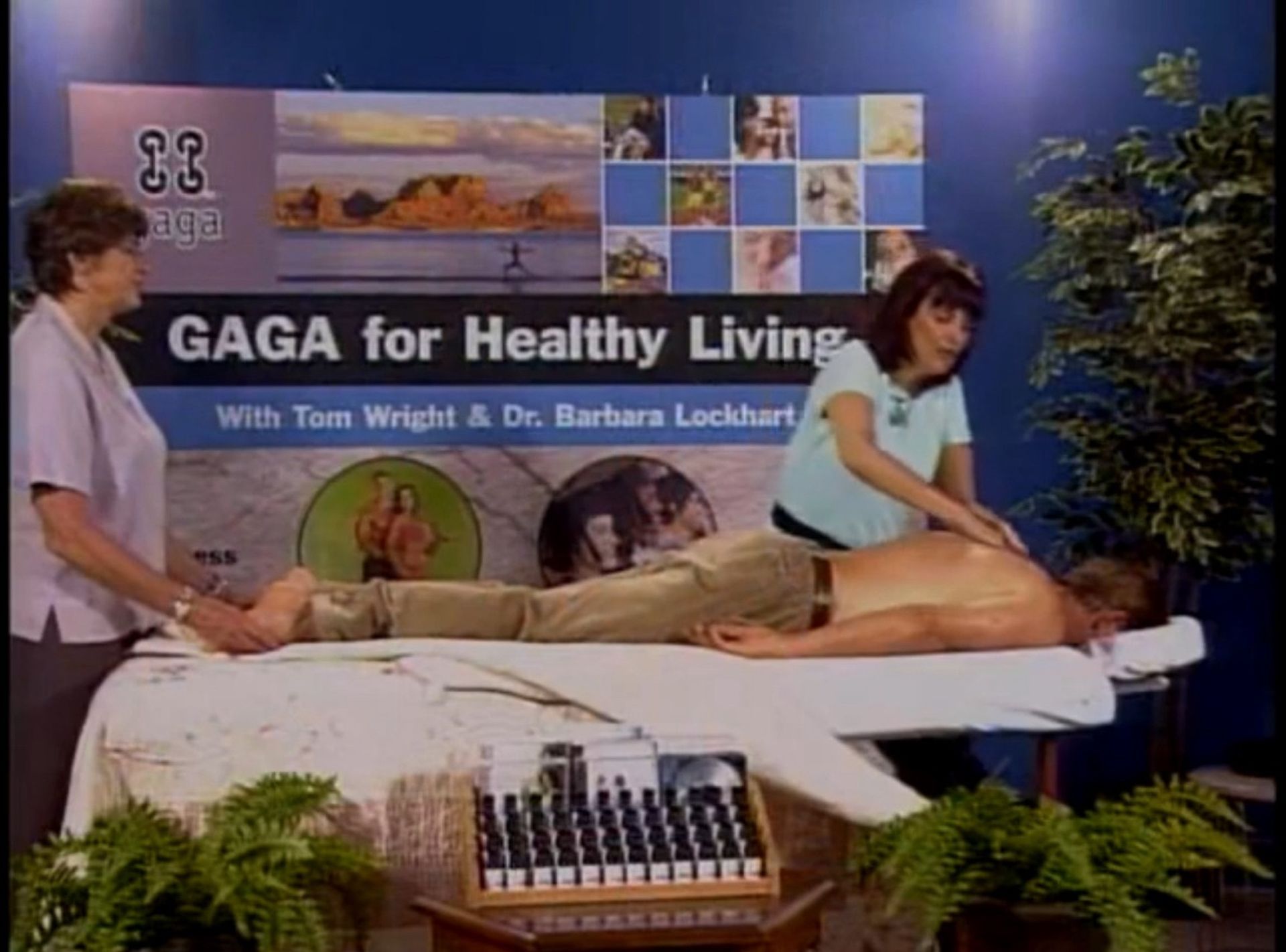 A man is getting a massage in front of a sign that says gaga for healthy living