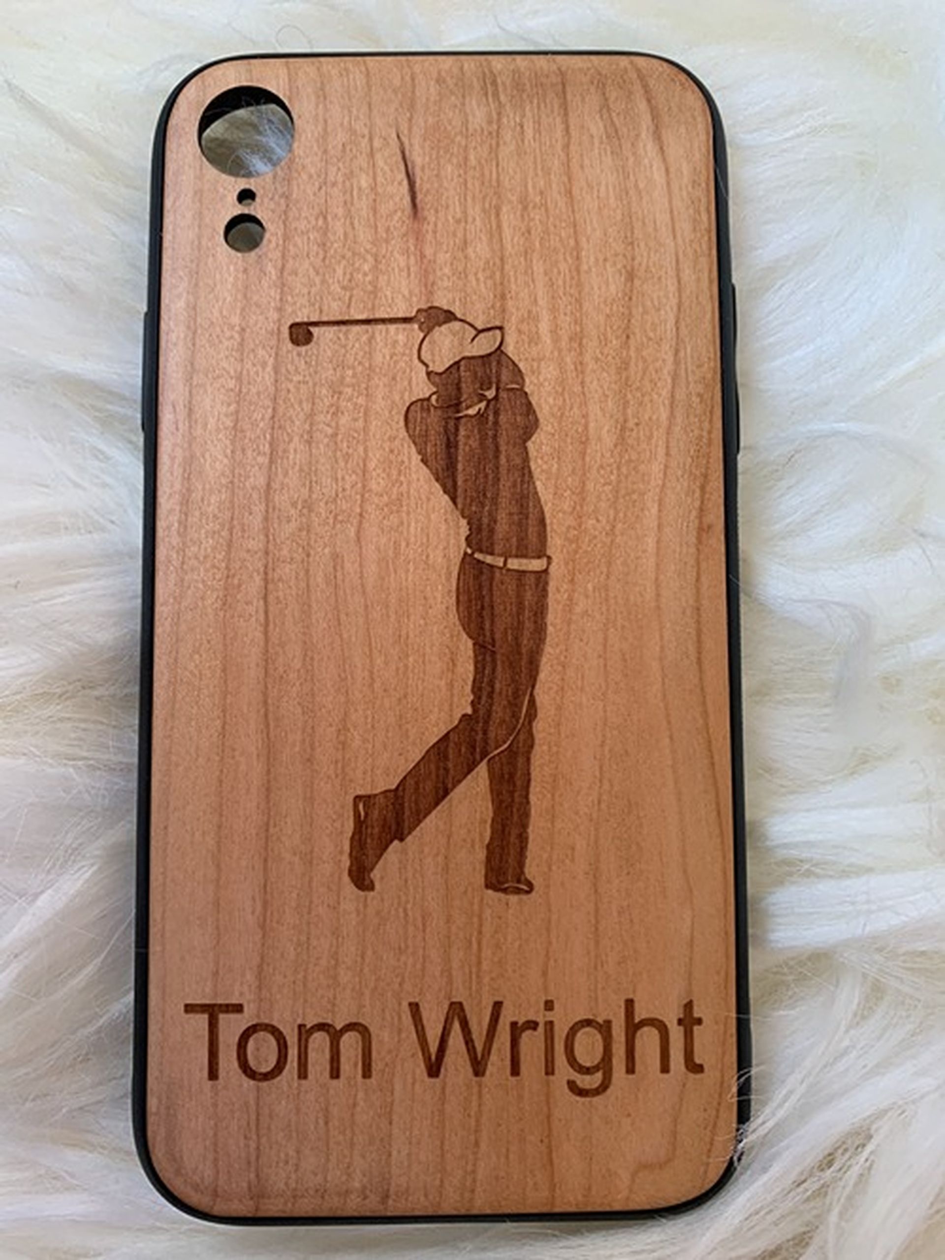 A wooden phone case with a picture of a golfer and the name tom wright on it.